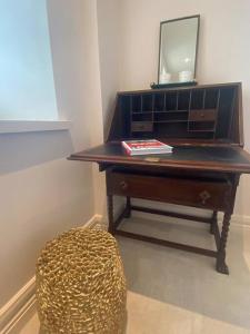 布莱克罗克Luxurious 2 bedroom apartment with sea view in Monkstown的一张桌子,一张镜子和一张凳子