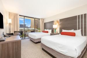 檀香山CASTLE at Palms at Waikīkī的酒店客房设有两张床和一台平面电视。