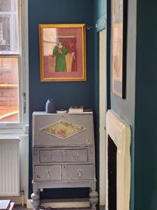 布里斯托John Street Apartment 3的一间蓝色的房间,配有梳妆台和墙上的绘画