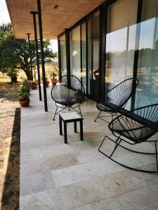 圣米格尔-德阿连德Casa Terra SMA的庭院设有两把黑色椅子和一张长凳