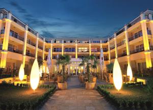 沙博伊茨Hotel Gran BelVeder & Ostsee Therme Resort & Spa的酒店拥有一座棕榈树和灯光的庭院