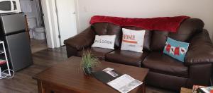 基洛纳WineDownHere - Lic. 75806的客厅配有带枕头的棕色皮沙发