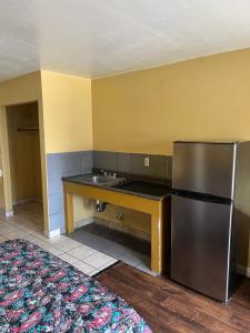 圣贝纳迪诺朝阳公园旅馆&套房的厨房配有不锈钢冰箱和水槽