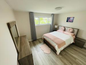 多伦多Luxurious Cozy House in Bluffs with Lake View的一间卧室配有带粉红色枕头的床和窗户。