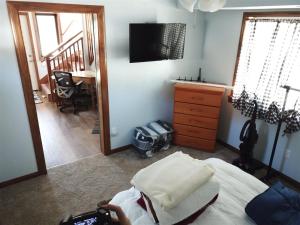 六月湖Rr-gull Lake Baby House的一间卧室配有一张床、一张书桌和一台电视