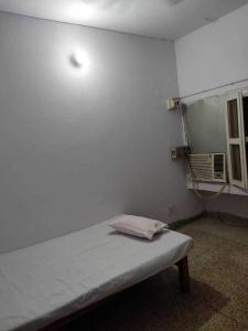 巴特那OYO Swaraj Guest House的一间设有一张墙壁上灯床的房间