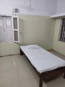 巴特那OYO Swaraj Guest House的一间小房间,房间内设有一张床