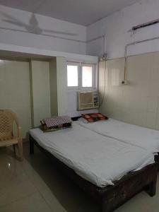 巴特那OYO Swaraj Guest House的窗户客房内的一张大床