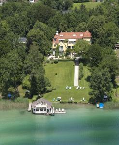 沃尔特湖畔韦尔登Hotel Seeschlößl Velden的享有房子和湖泊的空中景致