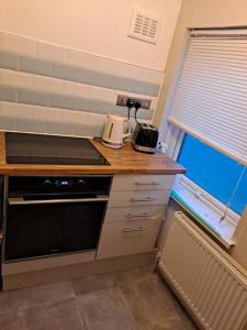 CanleyTwo bedroom maisonette close toWarwick Uni的厨房配有带炉灶的台面和窗户