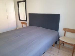 瑟德港Välrenoverad fin lägenhet i charmigt område的一间卧室配有蓝色的床和两把椅子