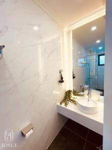 大叻Joyce Boutique Coffee & Stay的白色的浴室设有水槽和镜子
