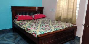 拉加蒙德里OYO HOME 81185 Srinivas Service Home的卧室内的一张带红色枕头的床
