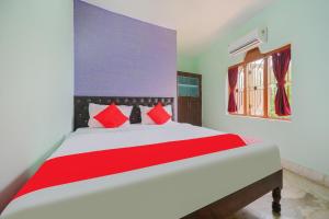 布巴内什瓦尔OYO Flagship 81152 Hotel Raz Stays的一间卧室配有一张带红色枕头的大床