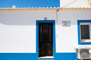 AlmádenaCasa Sabino的蓝白色的建筑,有门