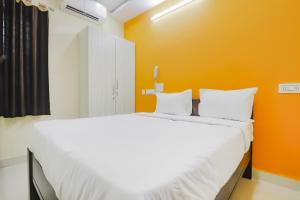 GachibowliHome Sri Balaji Luxary Rooms Near Inorbit Mall Cyberabad的一间卧室配有一张白色大床和橙色墙壁