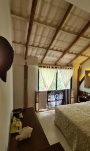图卢姆Chiibal的一间卧室配有一张床、一张桌子和一个窗户。