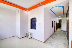 瓜廖尔OYO 81146 Hotel Prashant Villa的一间拥有白色墙壁和橙色天花板的客房