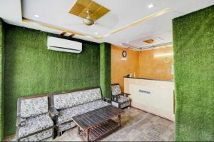 瓜廖尔OYO 81146 Hotel Prashant Villa的一间设有长凳和绿色墙壁的等候室