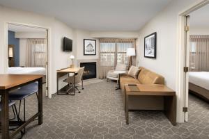 森特尼尔丹佛南/帕克迈德斯购物中心原住客栈的酒店客房设有床和客厅。