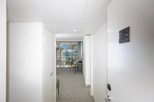 悉尼悉尼曼利海滩塞贝尔酒店的一条带白色门的走廊和一个用餐室