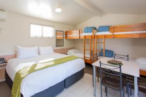陶波陶波湖度假村 的一间卧室配有两张双层床和一张书桌