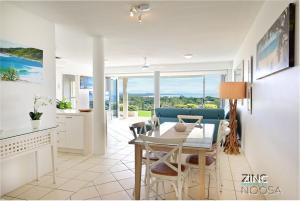 努萨角Crest Premium View Apartment 19的厨房以及带桌椅的用餐室。