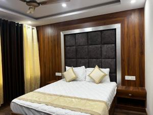 乔斯希马特HOTEL SHAILJA & AD CONTINENTAL RESTAURANT的一间卧室配有一张大床和黑色床头板