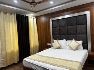 乔斯希马特HOTEL SHAILJA & AD CONTINENTAL RESTAURANT的一间卧室配有一张大床和黑色床头板