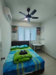 吉隆坡Da Best Guesthouse One Maxim Sentul Nice Cozy Condo 3 Rooms Aircond in Sentul KL的一间卧室配有一张带绿色床单的床和吊扇