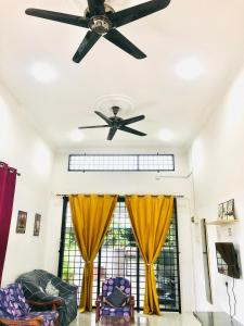 太平Homestay Lestary near Taiping Fast WIFI Netflix的客厅配有吊扇和黄色窗帘