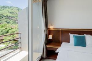 卡伦海滩德卡隆酒店的一间卧室设有一张床和一个美景阳台