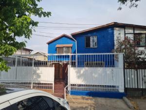 圣地亚哥Apartamento Interior 2do Piso Casa, 026 Quilicura的白色围栏后面的蓝色房子