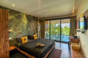 阿伯来The Hosteller Goa, Arpora的一间卧室设有一张大床和一个大窗户