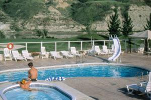 莱斯布里奇Paradise Canyon Golf Resort, Signature Condo 382的坐在度假村游泳池里的男人