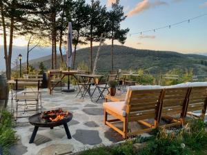 拉莫利纳Minds & Mountains Eco Lodge的庭院设有火坑、长凳和桌子