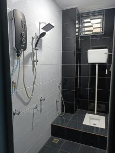 克提RIANI HOMESTAY的带淋浴的浴室和墙上的电话