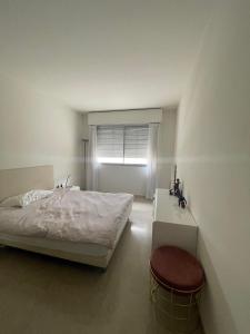 蒙特卡罗F1 Exclusive 100-sqm Monaco Apartment with Private Parking的一间卧室配有一张床、一个凳子和一扇窗户