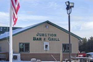 BabbittJunction Inn Suites & Conference Center的前面有旗帜的酒吧和烧烤店