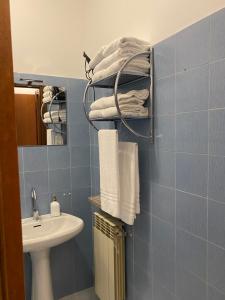 塞拉瓦莱·斯克里维亚YOUR HOME OUTLET 6的蓝色瓷砖浴室设有水槽和毛巾