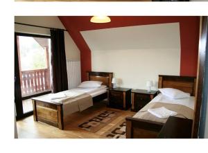 科利比塔Pensiunea Lac Colibita的一间卧室设有两张床和大窗户