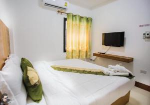 程逸府Staychill Resort的卧室配有白色的床和电视。