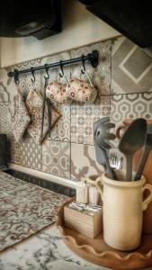 格罗塔列La Nghioscia的厨房墙上有一壶餐具
