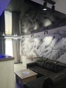 苏瓦乌基IGO-Apartament- 2 sypialnie i Salon的带沙发和大理石墙的客厅