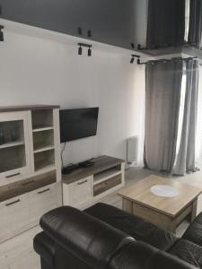 苏瓦乌基IGO-Apartament- 2 sypialnie i Salon的客厅配有沙发和桌子
