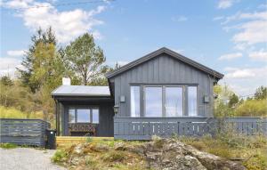 KopervikAwesome Home In Kopervik With Wifi的前面有长凳的灰色房子