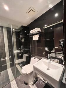 吉隆坡Hotel Aman Kuala Lumpur的浴室配有卫生间、盥洗盆和淋浴。