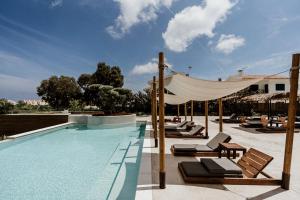 普罗塔拉斯Cavo Zoe Seaside Hotel的一个带躺椅和天篷的游泳池