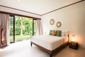 乌鲁瓦图梦景别墅的一间卧室设有一张床和一个大窗户