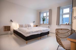 布罗斯特Skovsgård Hotel的一间卧室设有一张大床和两个窗户。